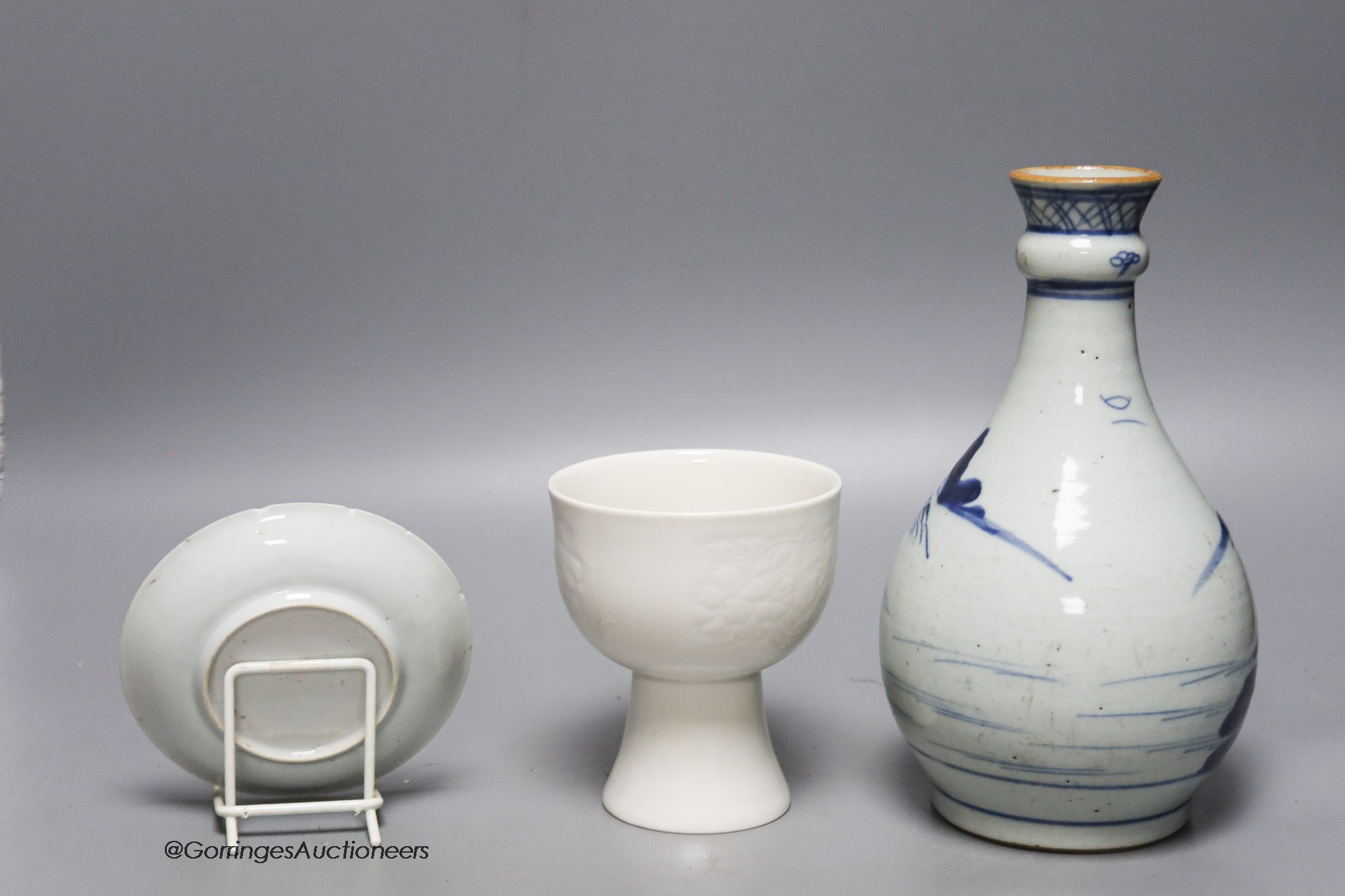 An 18th century Chinese blue and white bottle vase, together with a saucer and blanc de chine stem cup, 22cm